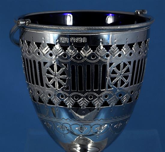 A late Victorian silver swing handled sugar basket with a blue glass liner, by Atkin Brothers, height 165mm, weight 4.9oz/154grms.